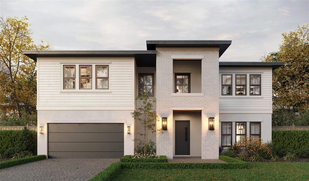 view of front facade featuring driveway, a garage, brick siding, and stucco siding
