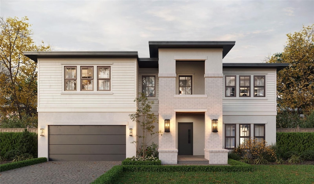 view of front of property featuring driveway, an attached garage, and stucco siding