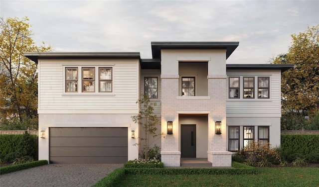 view of front of property featuring driveway, an attached garage, and stucco siding
