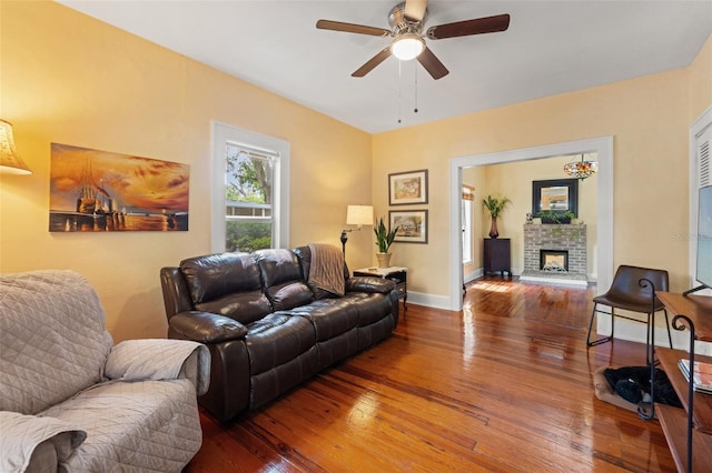 1001 E Crawford St, Tampa, FL 33604 - living room with wood-type flooring, ceiling fan, a fireplace with raised hearth, and baseboards