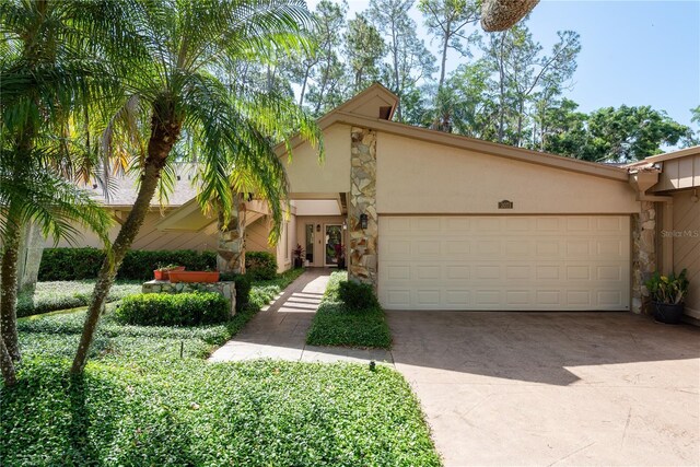 3071 Bolt Dr, Palm Harbor, FL 34685 - mid-century inspired home featuring stone siding, stucco siding, a garage, and driveway