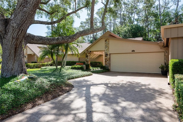 3071 Bolt Dr, Palm Harbor, FL 34685 - view of front of property featuring an attached garage, concrete driveway, stucco siding, and stone siding