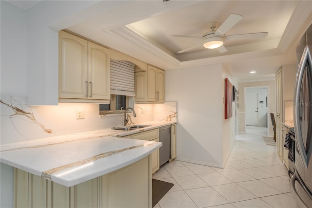 3071 Bolt Dr, Palm Harbor, FL 34685 - kitchen with cream cabinetry, a raised ceiling, stainless steel appliances, a peninsula, and a sink