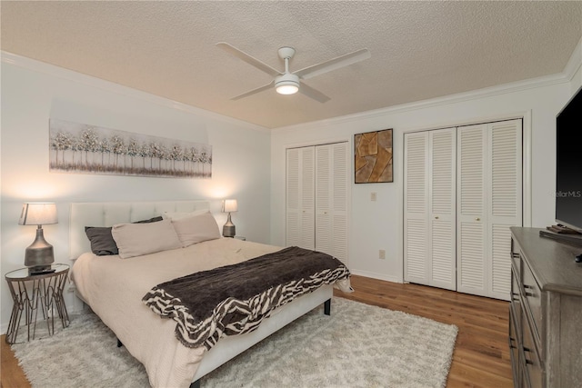 3071 Bolt Dr, Palm Harbor, FL 34685 - bedroom with ornamental molding, multiple closets, wood finished floors, a textured ceiling, and baseboards