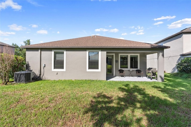 4690 Coachford Dr, Wesley Chapel, FL 33543 - back of property featuring central AC, a patio, a lawn, stucco siding, and roof with shingles