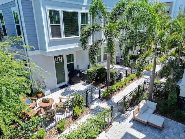view of exterior entry featuring a patio, fence, and stucco siding