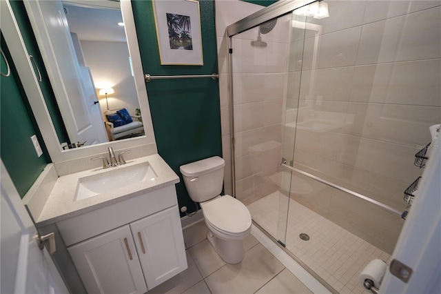 bathroom with a stall shower, toilet, vanity, and tile patterned flooring