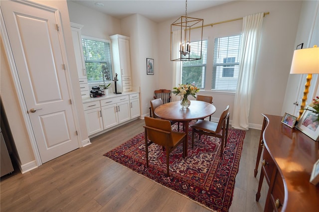 dining space with a chandelier, wood finished floors, and baseboards