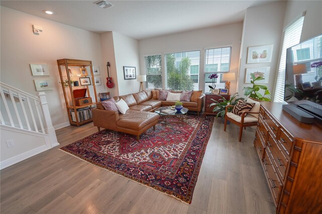 living area featuring healthy amount of natural light, wood finished floors, stairway, and recessed lighting