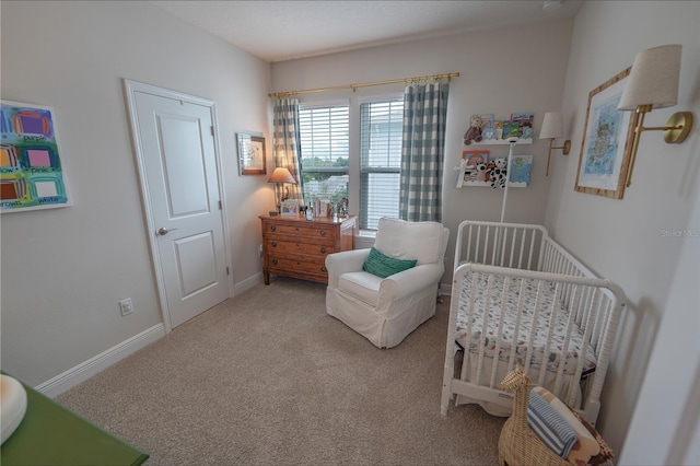 bedroom with carpet, a crib, and baseboards
