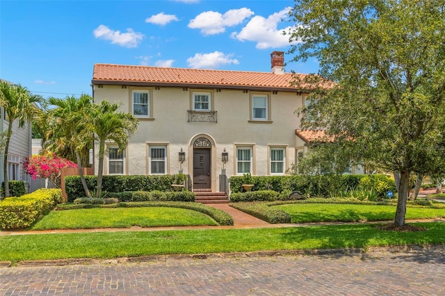 455 18th Ave NE, Saint Petersburg, FL 33704 - mediterranean / spanish-style house featuring a tile roof, a chimney, stucco siding, and a front lawn