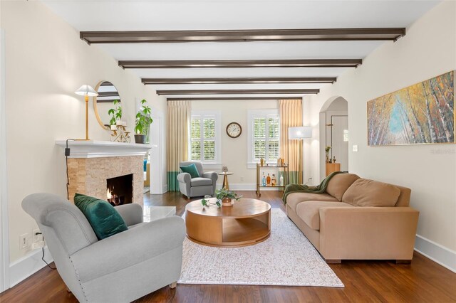455 18th Ave NE, Saint Petersburg, FL 33704 - living room with arched walkways, baseboards, a lit fireplace, beam ceiling, and dark wood-style floors