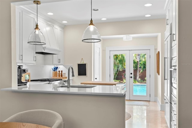 455 18th Ave NE, Saint Petersburg, FL 33704 - kitchen with a sink, a peninsula, white cabinetry, light countertops, and recessed lighting