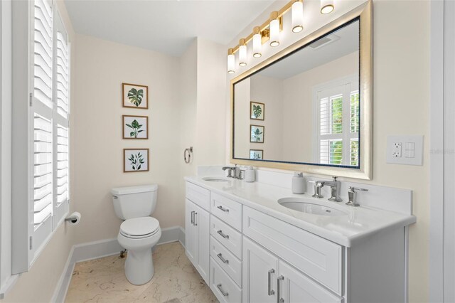 455 18th Ave NE, Saint Petersburg, FL 33704 - full bathroom featuring baseboards, marble finish flooring, toilet, and double vanity
