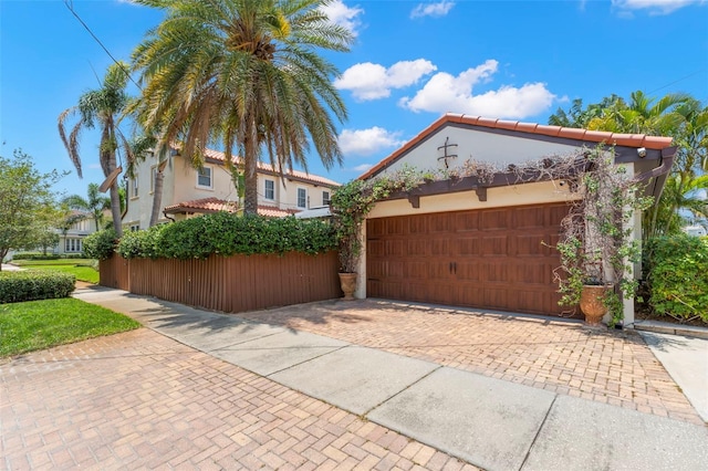 455 18th Ave NE, Saint Petersburg, FL 33704 - view of property exterior featuring decorative driveway, an attached garage, and stucco siding