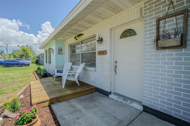 entrance to property featuring brick siding and a porch