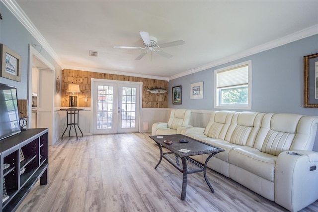 living room with french doors, crown molding, ceiling fan, wood finished floors, and wooden walls