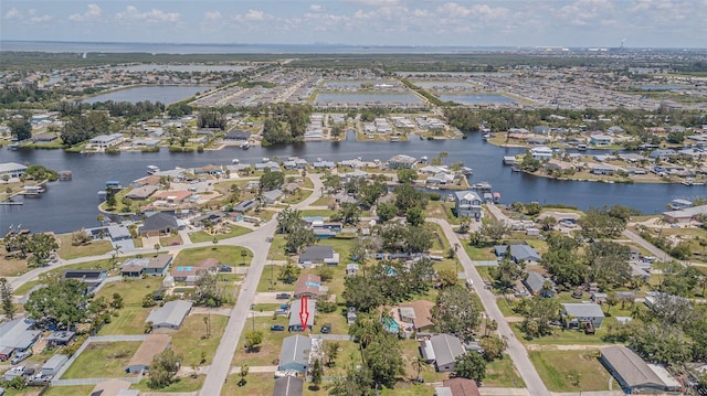 aerial view of property and surrounding area featuring a large body of water and nearby suburban area