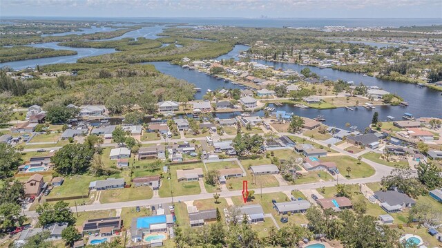 aerial view of property and surrounding area featuring a large body of water and nearby suburban area