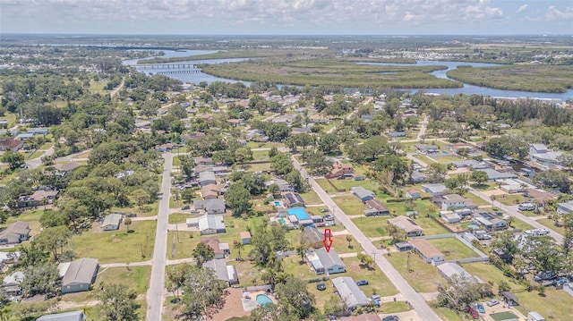 aerial view of property's location featuring a nearby body of water and nearby suburban area
