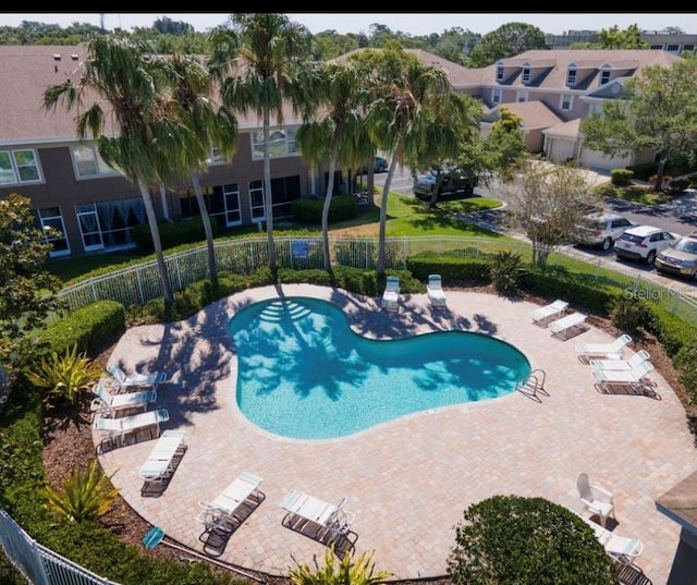 community pool with fence and a patio