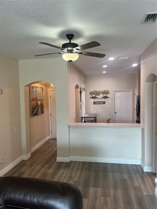 kitchen featuring arched walkways, dark wood-style flooring, ceiling fan, a textured ceiling, and recessed lighting