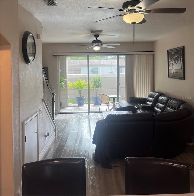 living area featuring ceiling fan, wood finished floors, and a textured ceiling