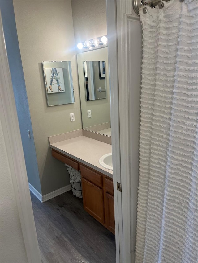 full bathroom featuring wood finished floors, vanity, and baseboards