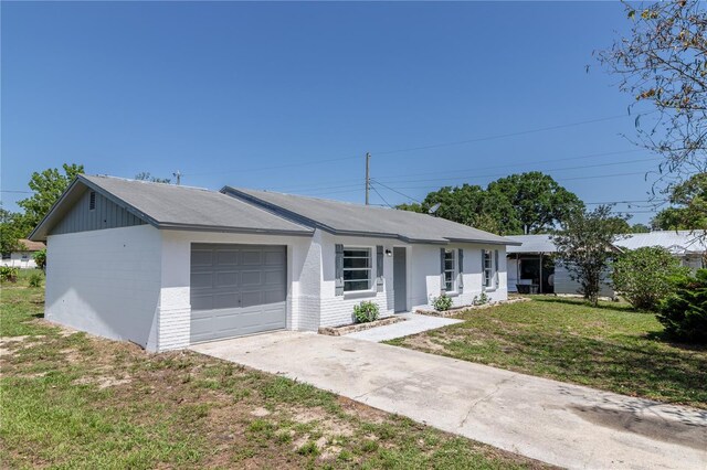 single story home with concrete driveway, a garage, and a front yard