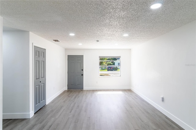 entrance foyer featuring wood finished floors, recessed lighting, baseboards, and a textured ceiling