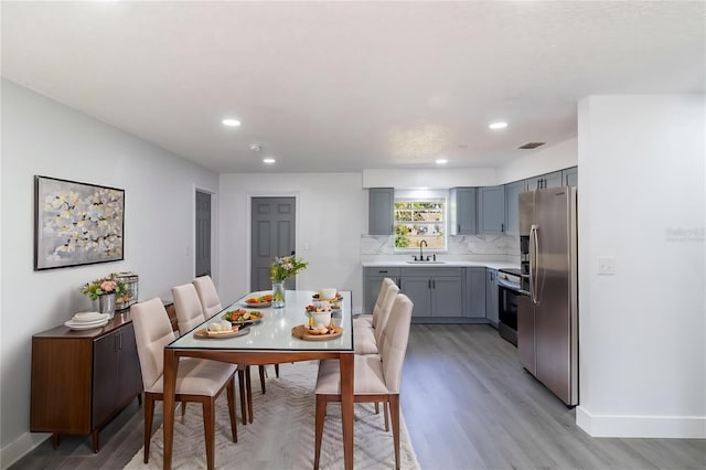 dining area with light wood-type flooring, recessed lighting, and baseboards