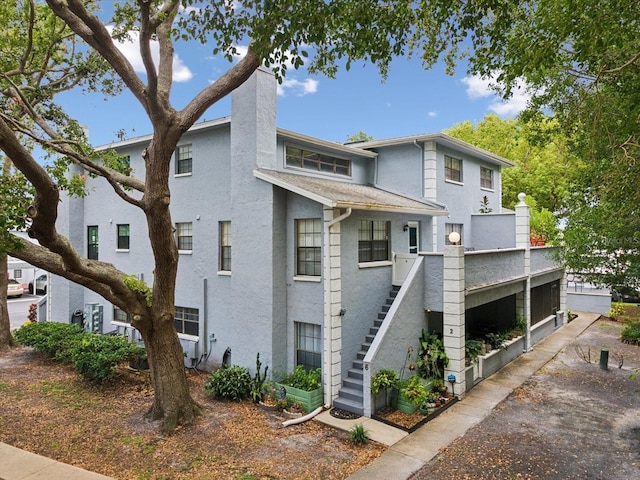 5729 Calais Blvd N Unit 6, Saint Petersburg, FL 33714 - view of front facade featuring stairs, stucco siding, and a chimney