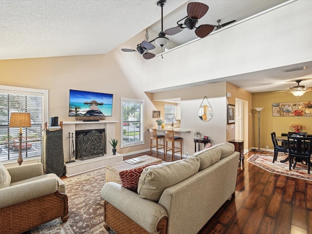 5729 Calais Blvd N Unit 6, Saint Petersburg, FL 33714 - living room with a ceiling fan, dark wood-style flooring, baseboards, a fireplace, and a textured ceiling