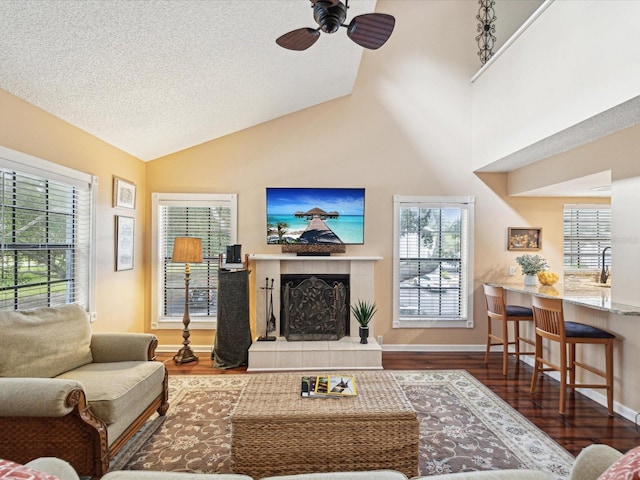 5729 Calais Blvd N Unit 6, Saint Petersburg, FL 33714 - living room featuring wood finished floors, a tile fireplace, ceiling fan, healthy amount of natural light, and lofted ceiling