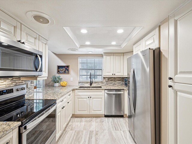 5729 Calais Blvd N Unit 6, Saint Petersburg, FL 33714 - kitchen featuring appliances with stainless steel finishes, a sink, a tray ceiling, backsplash, and recessed lighting