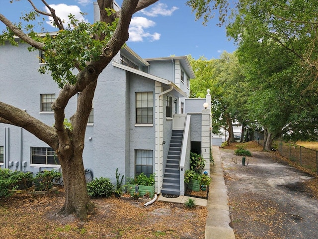 5729 Calais Blvd N Unit 6, Saint Petersburg, FL 33714 - view of front of house featuring stucco siding, stairway, and fence