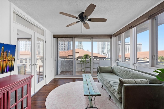 sunroom featuring plenty of natural light, wood finished floors, french doors, a textured ceiling, and baseboards