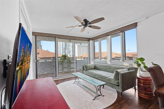 living room featuring ceiling fan, hardwood / wood-style floors, plenty of natural light, and a textured ceiling