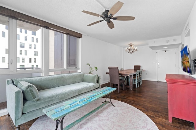 living room featuring wood finished floors, a chandelier, a ceiling fan, baseboards, and a textured ceiling