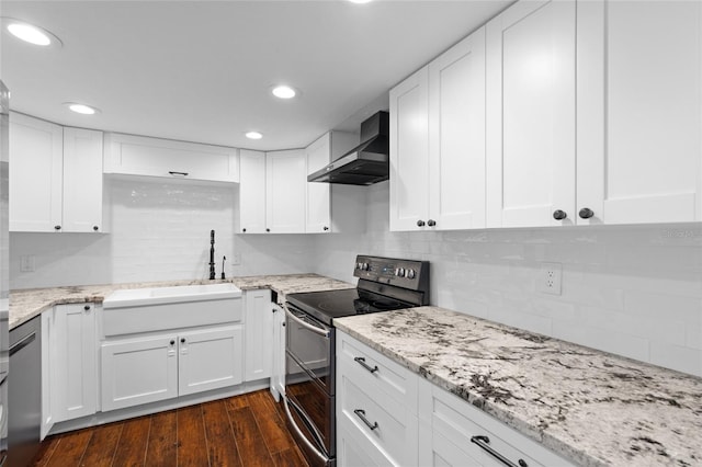 kitchen with stainless steel electric range, wall chimney exhaust hood, tasteful backsplash, a sink, and white cabinetry