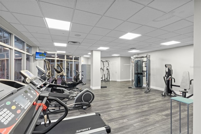 gym with wood finished floors, baseboards, and a paneled ceiling