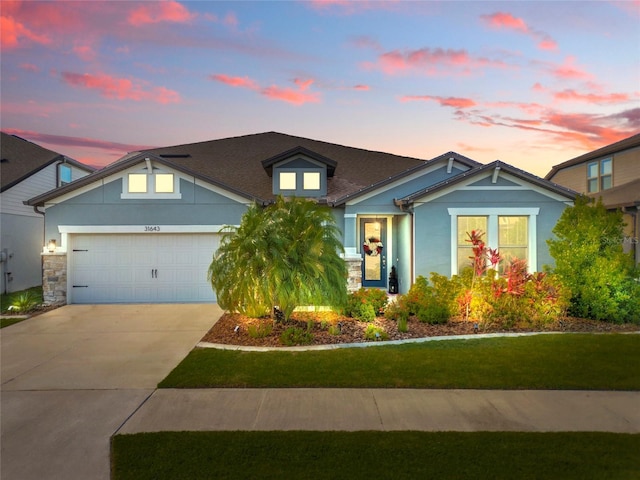 31643 Colada Drift Way, Wesley Chapel, FL 33545 - view of front of house featuring a garage, driveway, stone siding, and a lawn