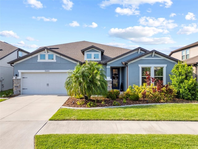 31643 Colada Drift Way, Wesley Chapel, FL 33545 - craftsman-style home featuring a garage, concrete driveway, a front yard, roof with shingles, and stone siding
