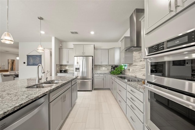 31643 Colada Drift Way, Wesley Chapel, FL 33545 - kitchen with appliances with stainless steel finishes, wall chimney exhaust hood, a sink, gray cabinets, and recessed lighting