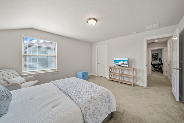 31643 Colada Drift Way, Wesley Chapel, FL 33545 - bedroom with light colored carpet, vaulted ceiling, baseboards, and a textured ceiling