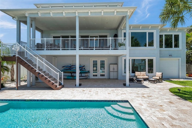 7115 Bay St, St Pete Beach, FL 33706 - rear view of house with french doors, an outdoor hangout area, a patio area, and an outdoor pool