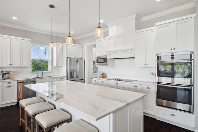 7115 Bay St, St Pete Beach, FL 33706 - kitchen featuring stainless steel appliances, a sink, a center island, recessed lighting, and white cabinets
