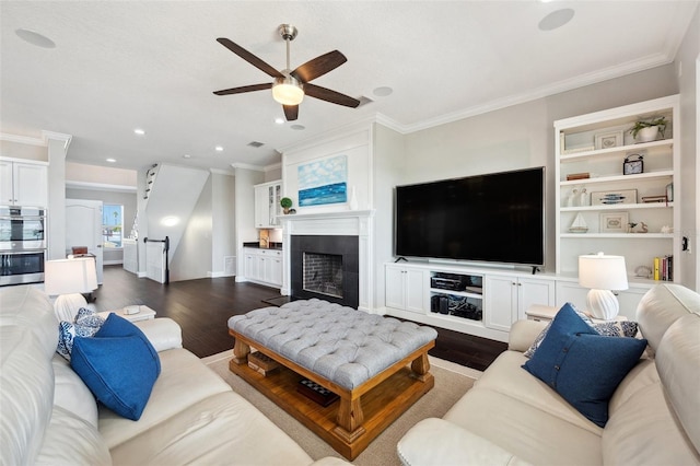 7115 Bay St, St Pete Beach, FL 33706 - living room featuring dark wood-style floors, a ceiling fan, crown molding, a fireplace, and recessed lighting