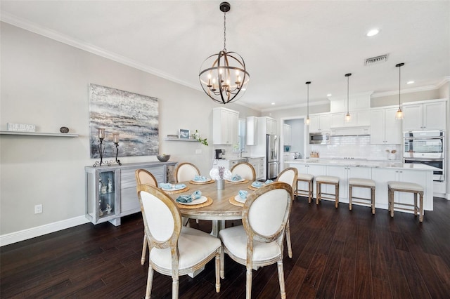 7115 Bay St, St Pete Beach, FL 33706 - dining space with a chandelier, dark wood-type flooring, recessed lighting, baseboards, and crown molding