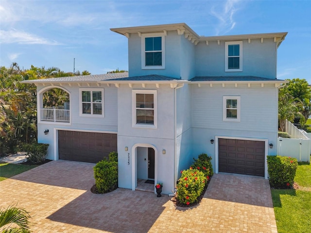 7115 Bay St, St Pete Beach, FL 33706 - raised beach house featuring a garage, decorative driveway, stucco siding, and a shingled roof
